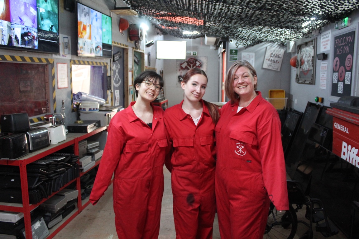 Customers in full safety equipment at our Kent rage room — coveralls, helmet, face shield and gloves