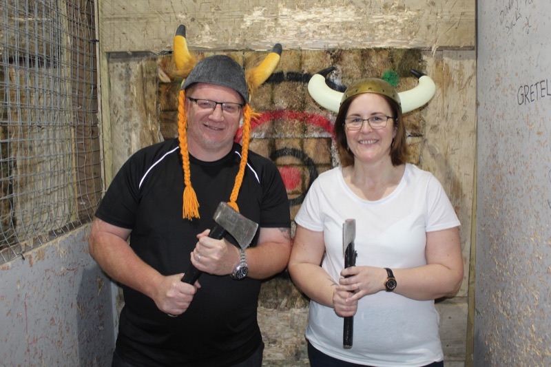 Two customers in viking hats holding axes in a Rage Out throwing lane